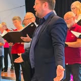 Hans Dur Molvik synger foran koret på vårkonserten i 2026.